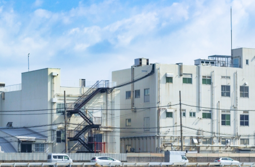 青空の下の本社外観